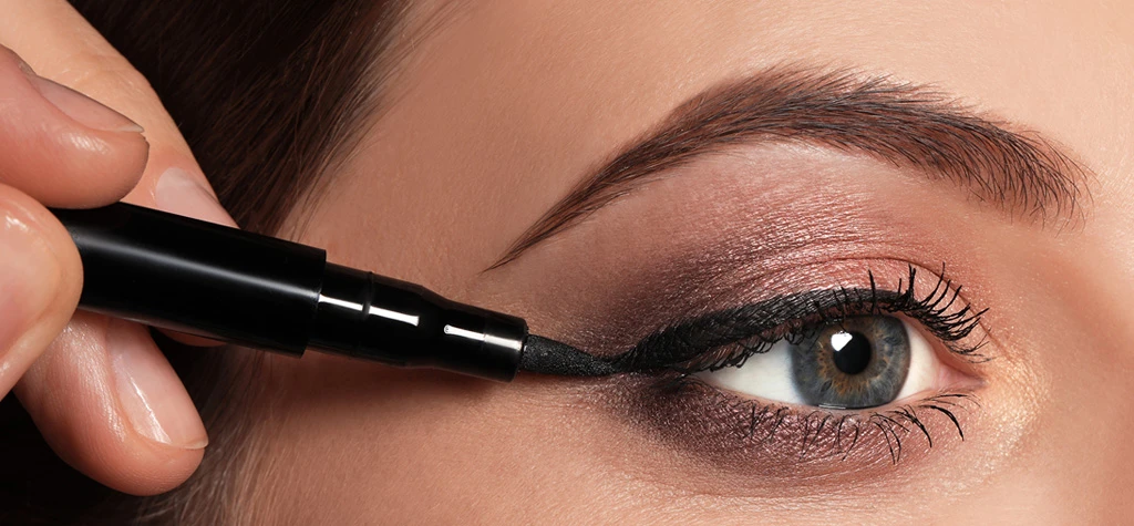 mujer utilizando delineador de ojos líquido mujer utilizando delineador de ojos líquido